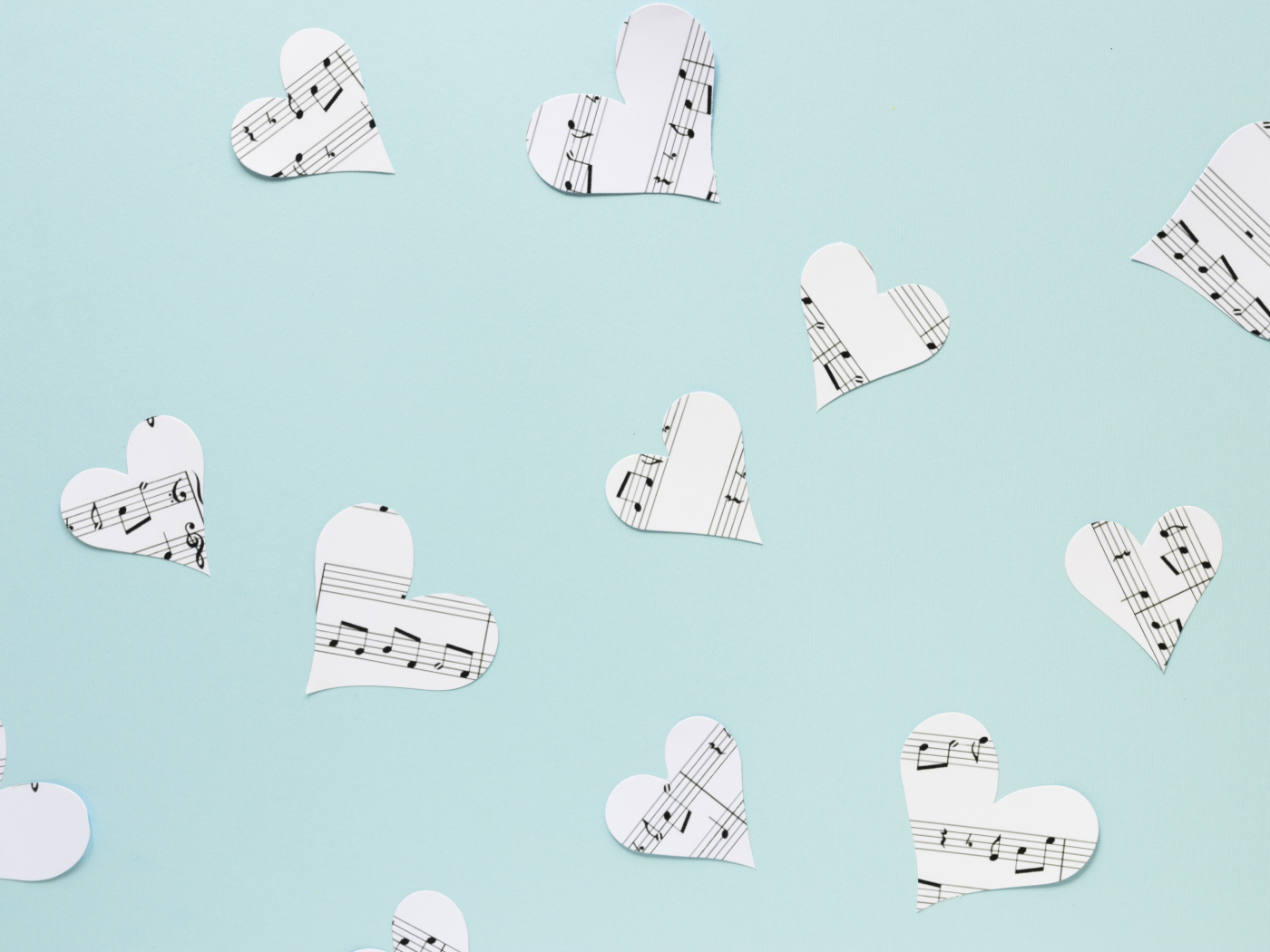 Сердечки из нотной тетради на голубом фоне