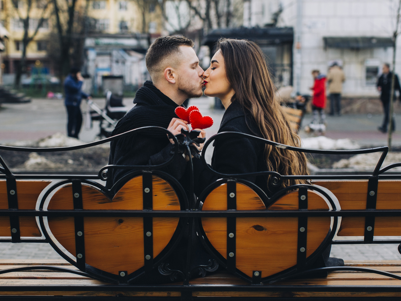 Поцелуй влюбленной пары на лавке в парке