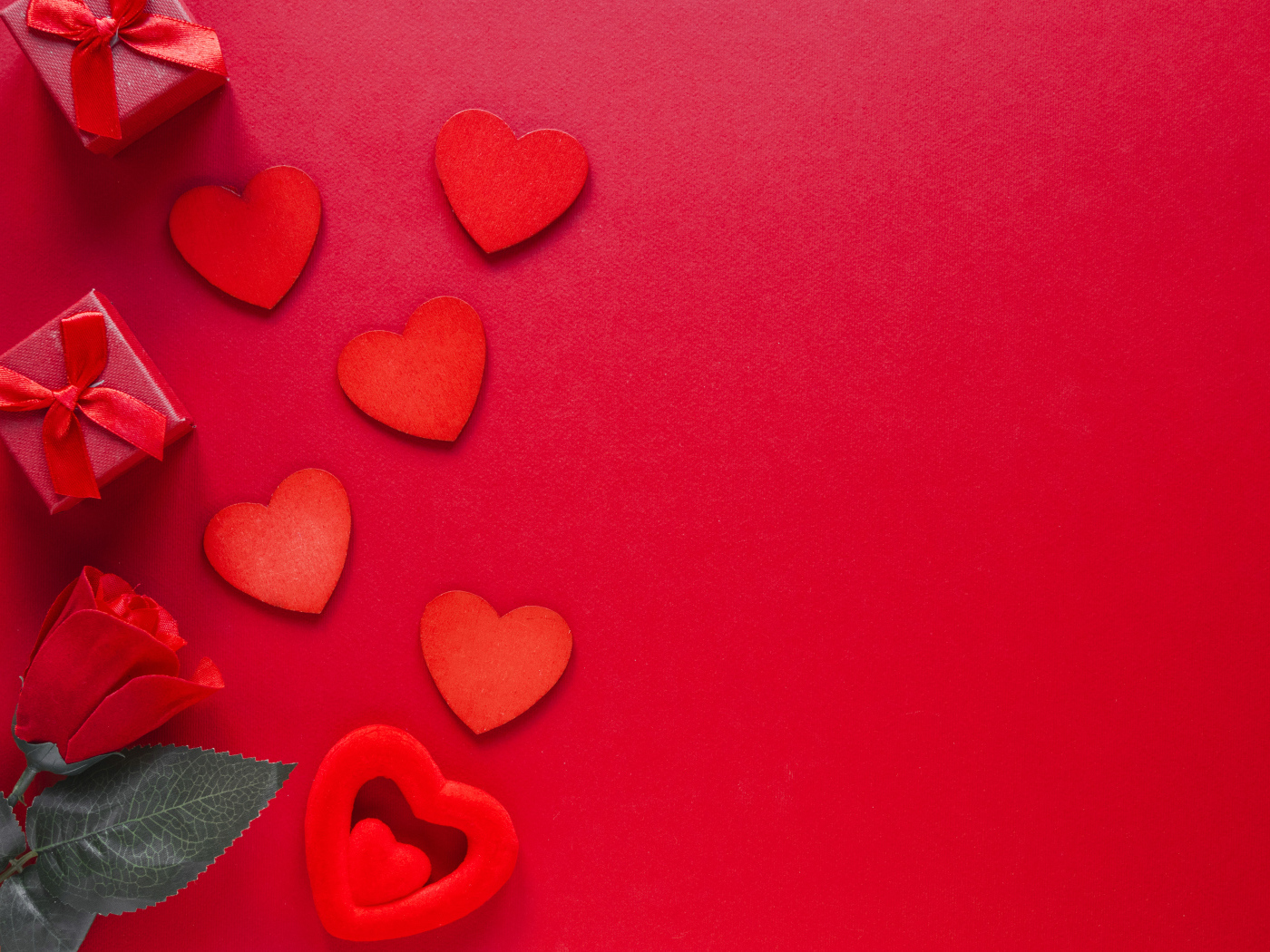 Бумажные сердечки с подарком и розой на красном фоне