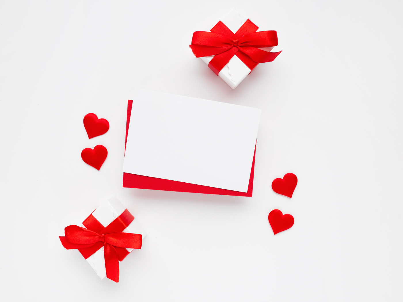 Красные сердечки, лист бумаги и подарки для шаблона открытки