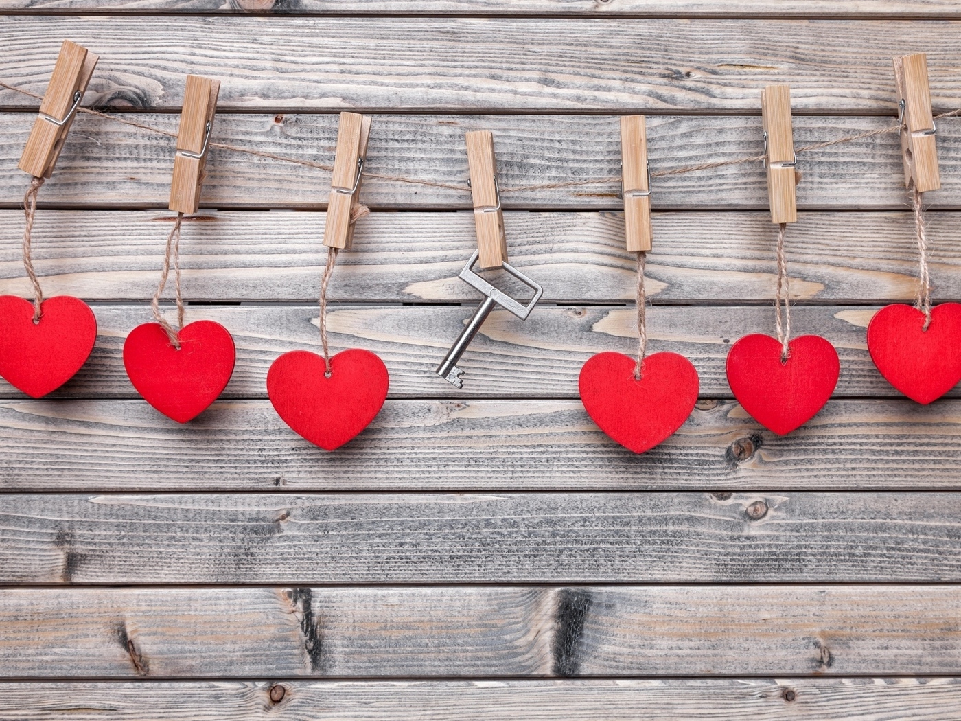 Красные сердечки и ключ с прищепками на веревке