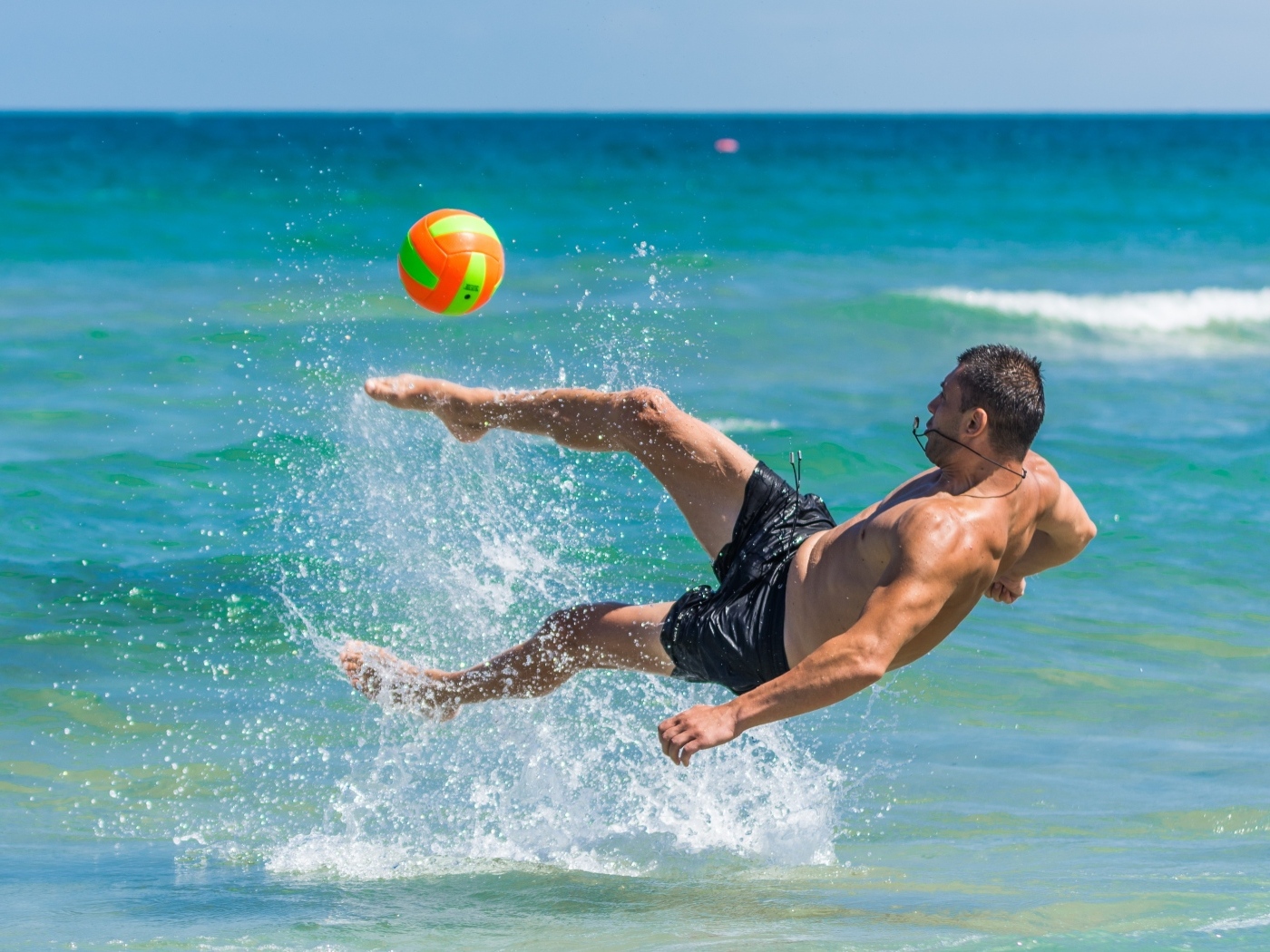 Мужчина играет в пляжный футбол