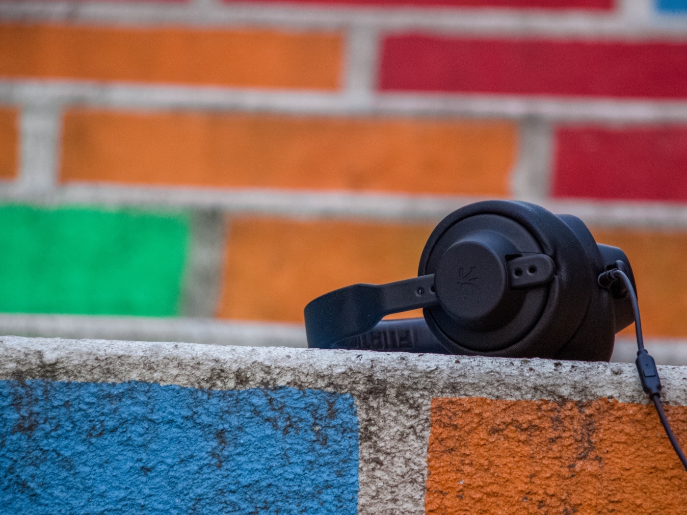 Черные наушники лежат на стене