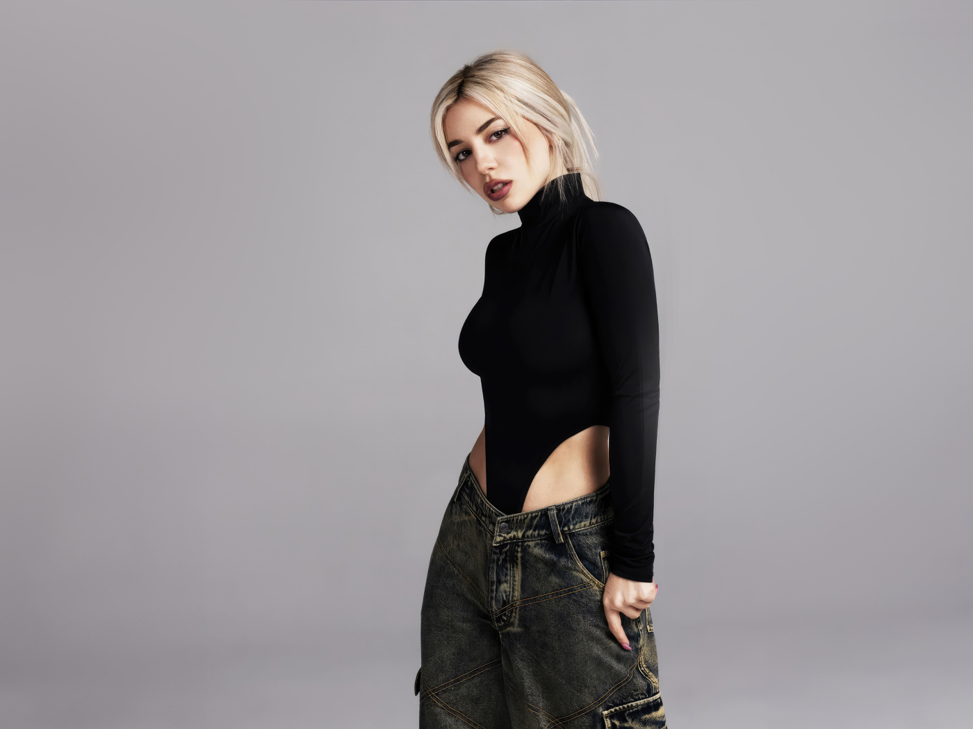 Милая блондинка певица  Эйва Макс на сером фоне