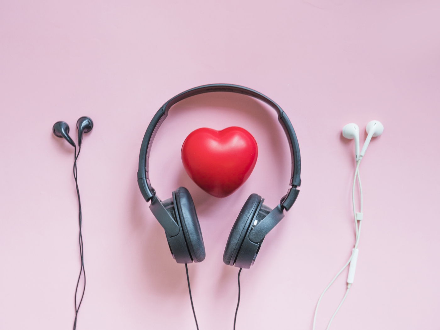 Наушники на розовом фоне с красным сердцем