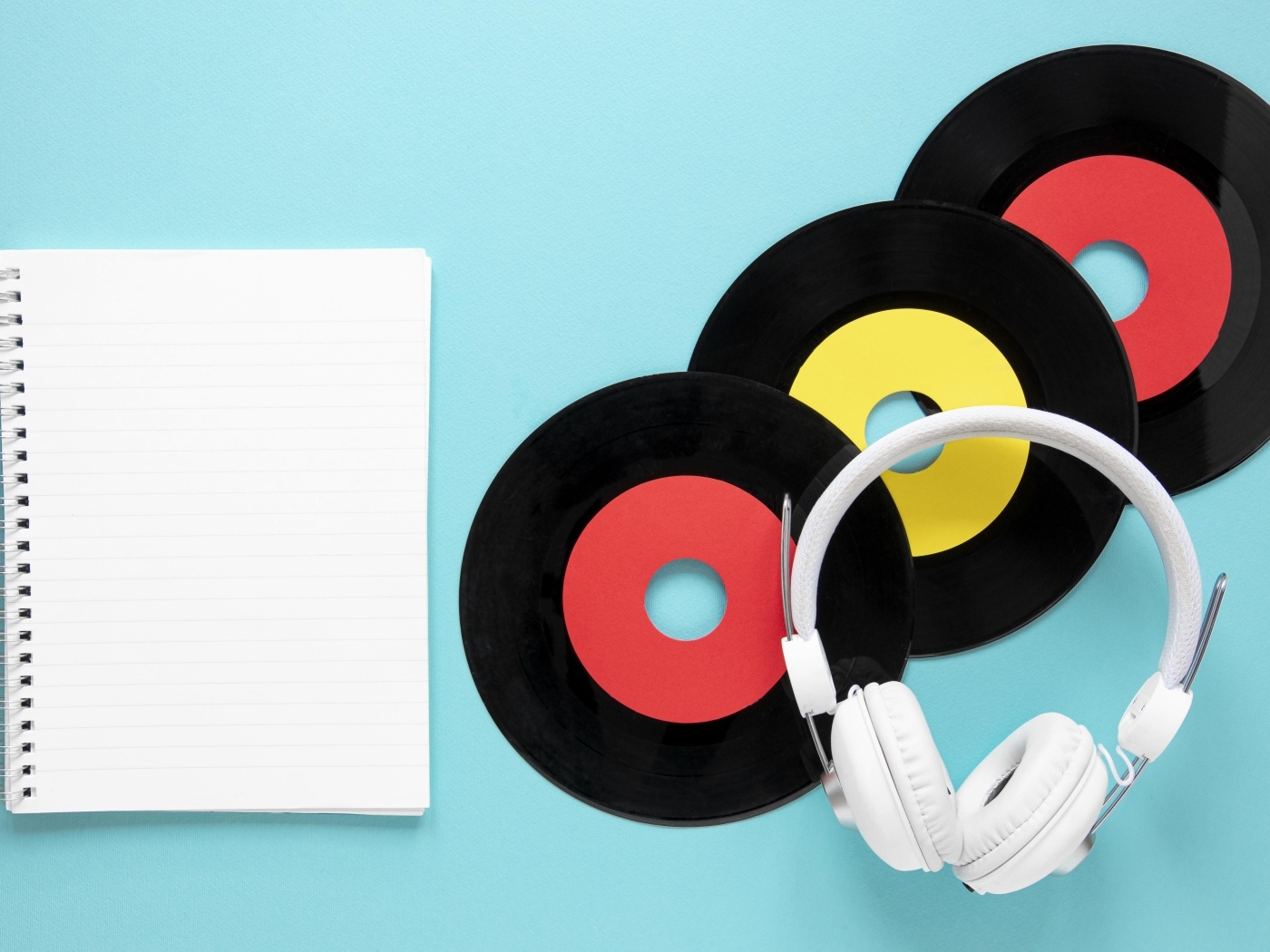 Пластинки на голубом фоне с блокнотом и наушниками