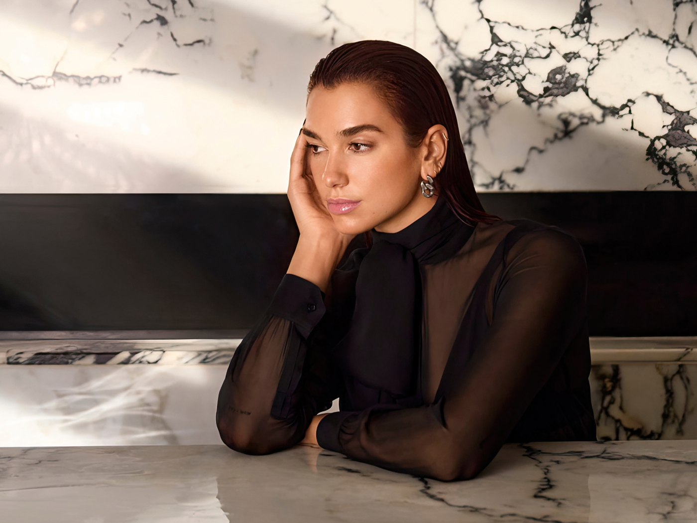 Грустная певица Дуа Липа сидит за столом