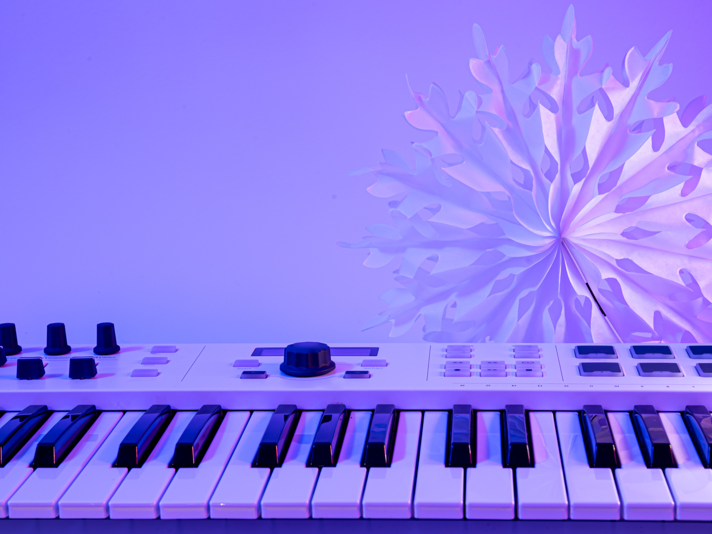 Синтезатор с бумажной снежинкой на фиолетовом фоне