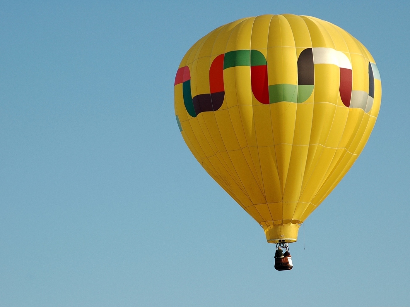 Большой желтый воздушный шар в голубом небе
