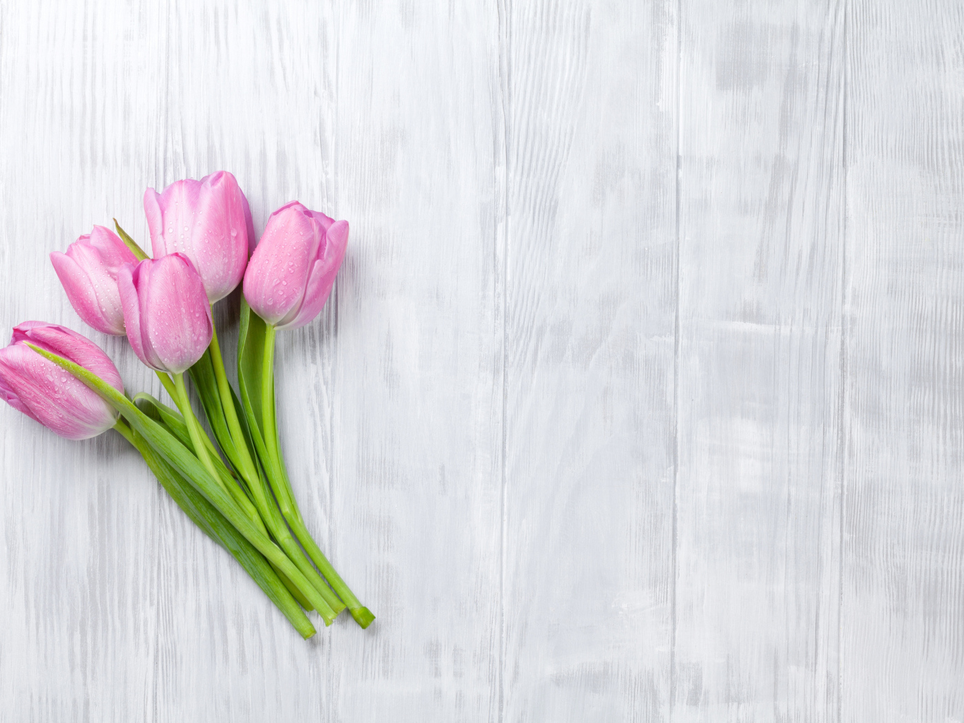 Розовые тюльпаны на сером деревянном столе