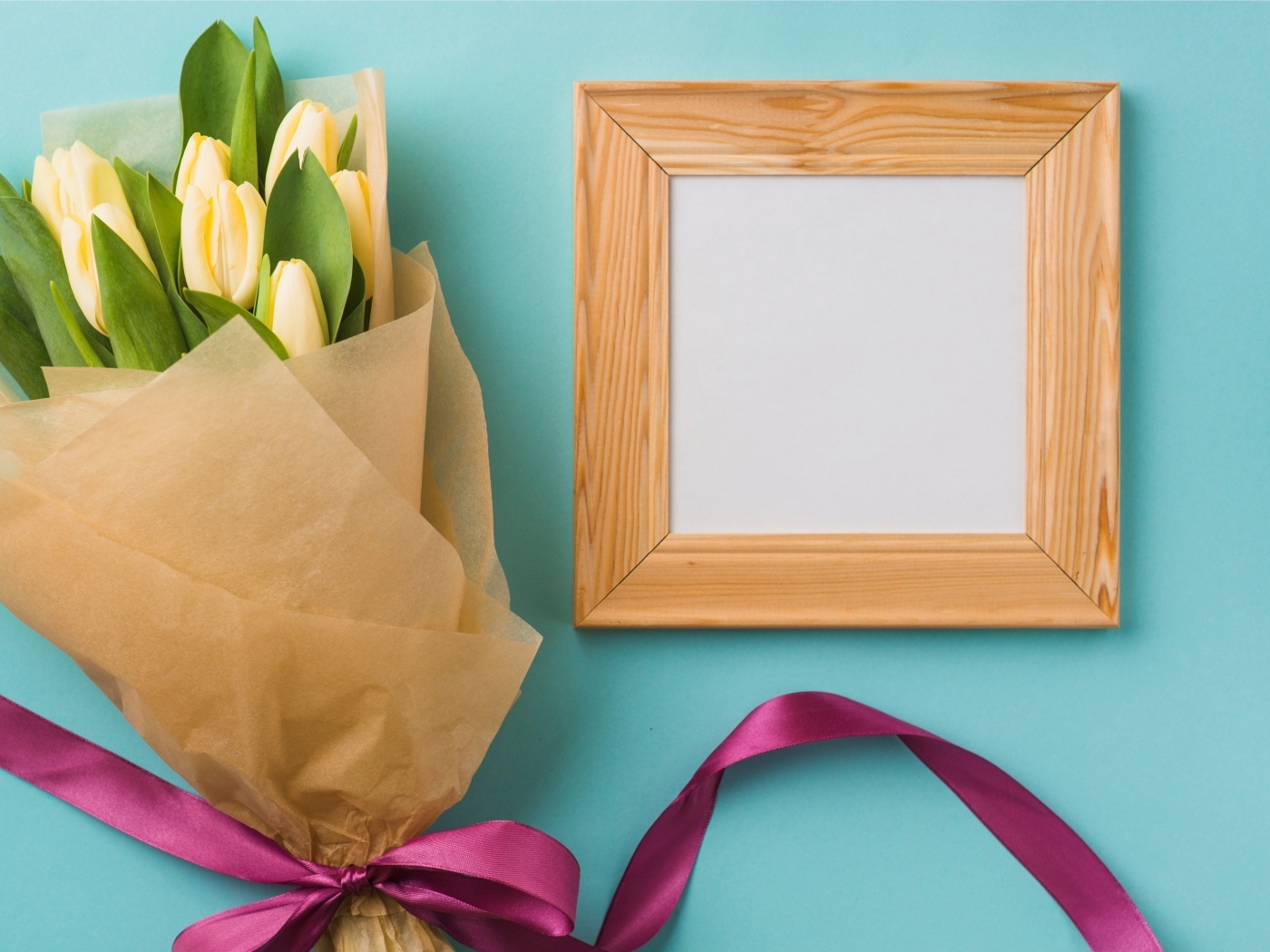 Деревянная рамка с букетом желтых тюльпанов на голубом фоне