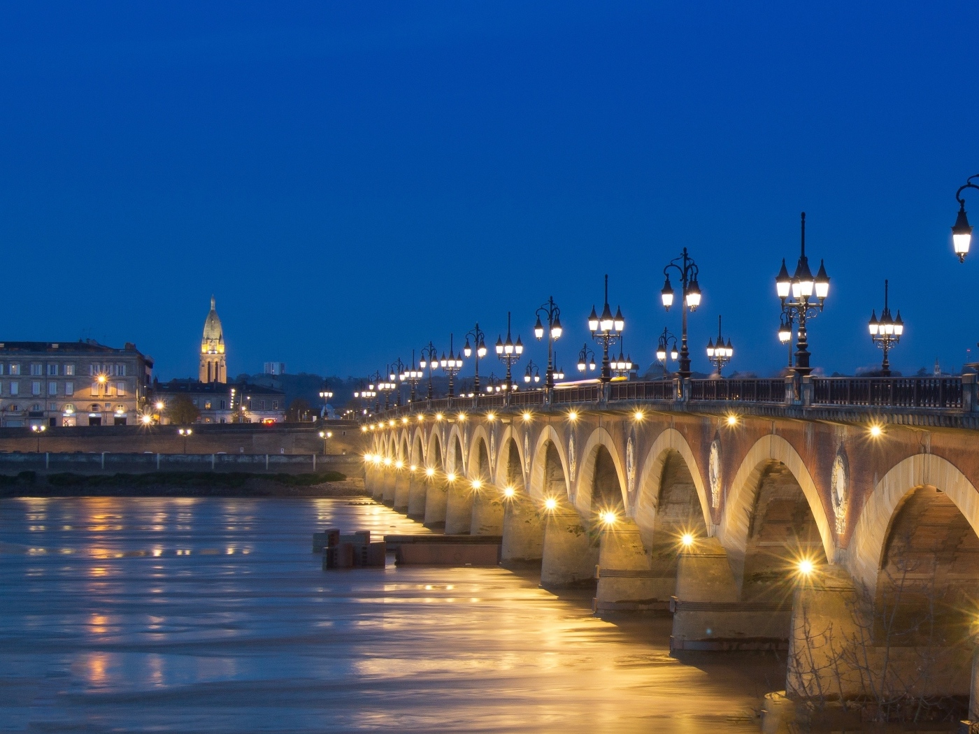 Красивый светящийся мост через реку ночью 