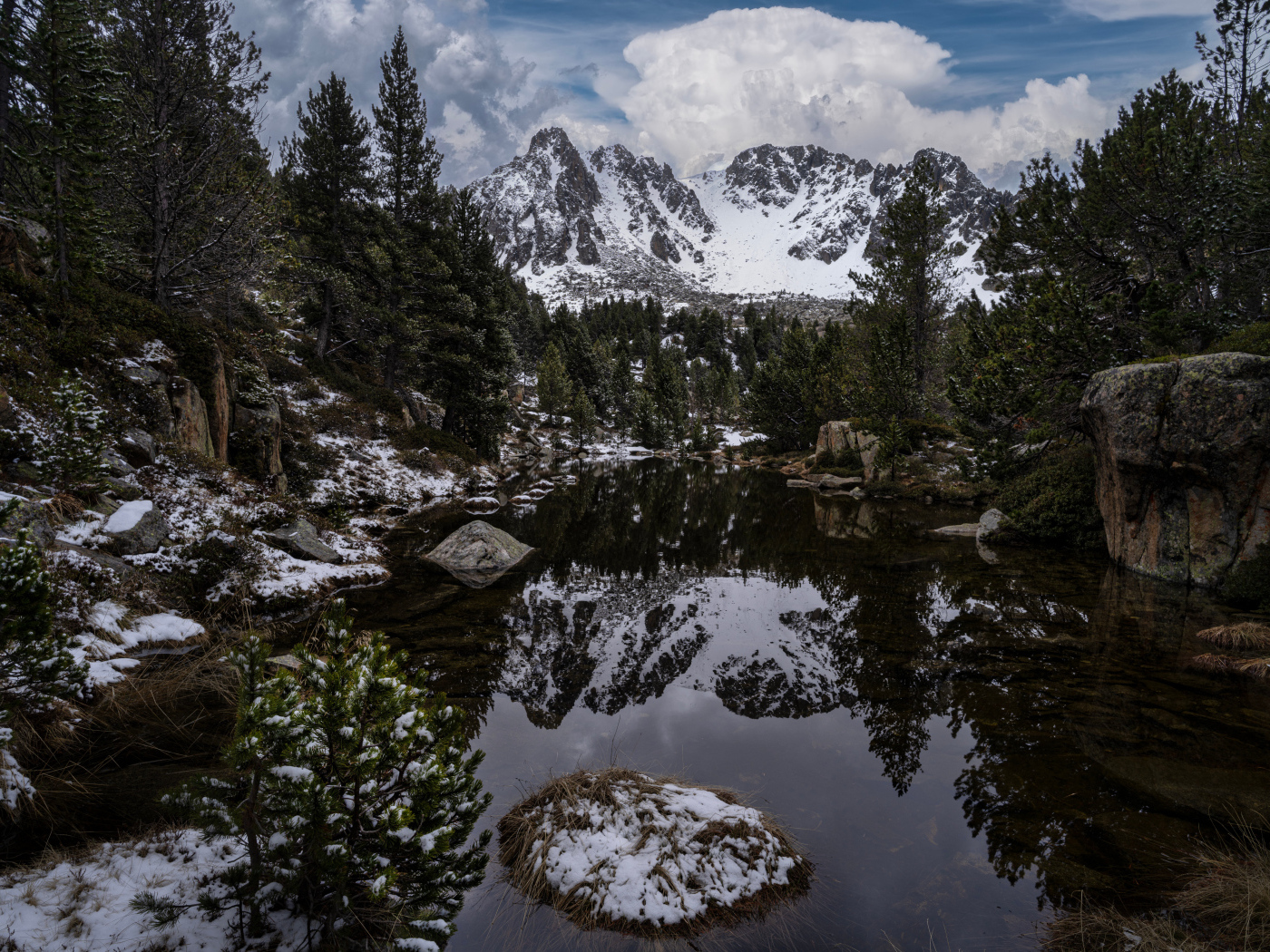 Холодная вода в озере с большими камнями на фоне гор