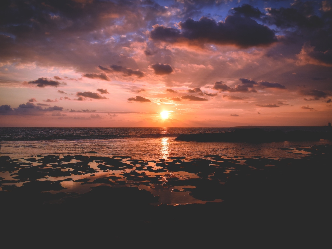 Закат яркого летнего солнца в небе над морем