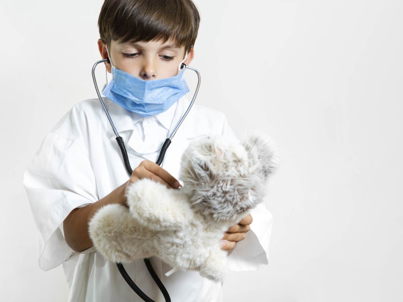 Мальчик в костюме врача с игрушечным медведем
