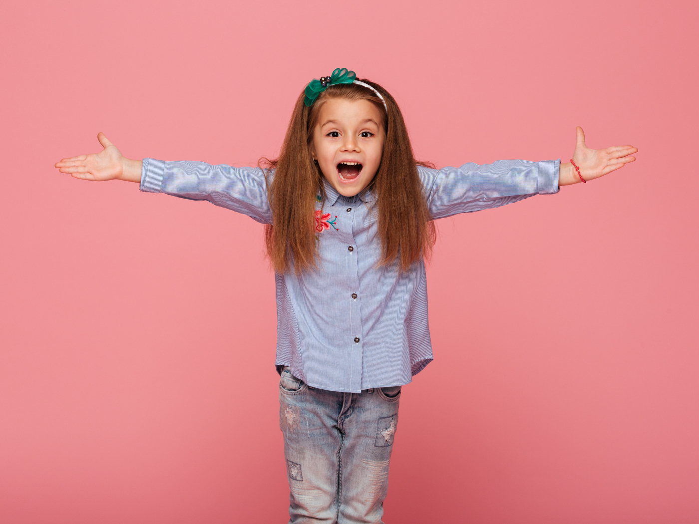 Счастливая маленькая девочка на розовом фоне