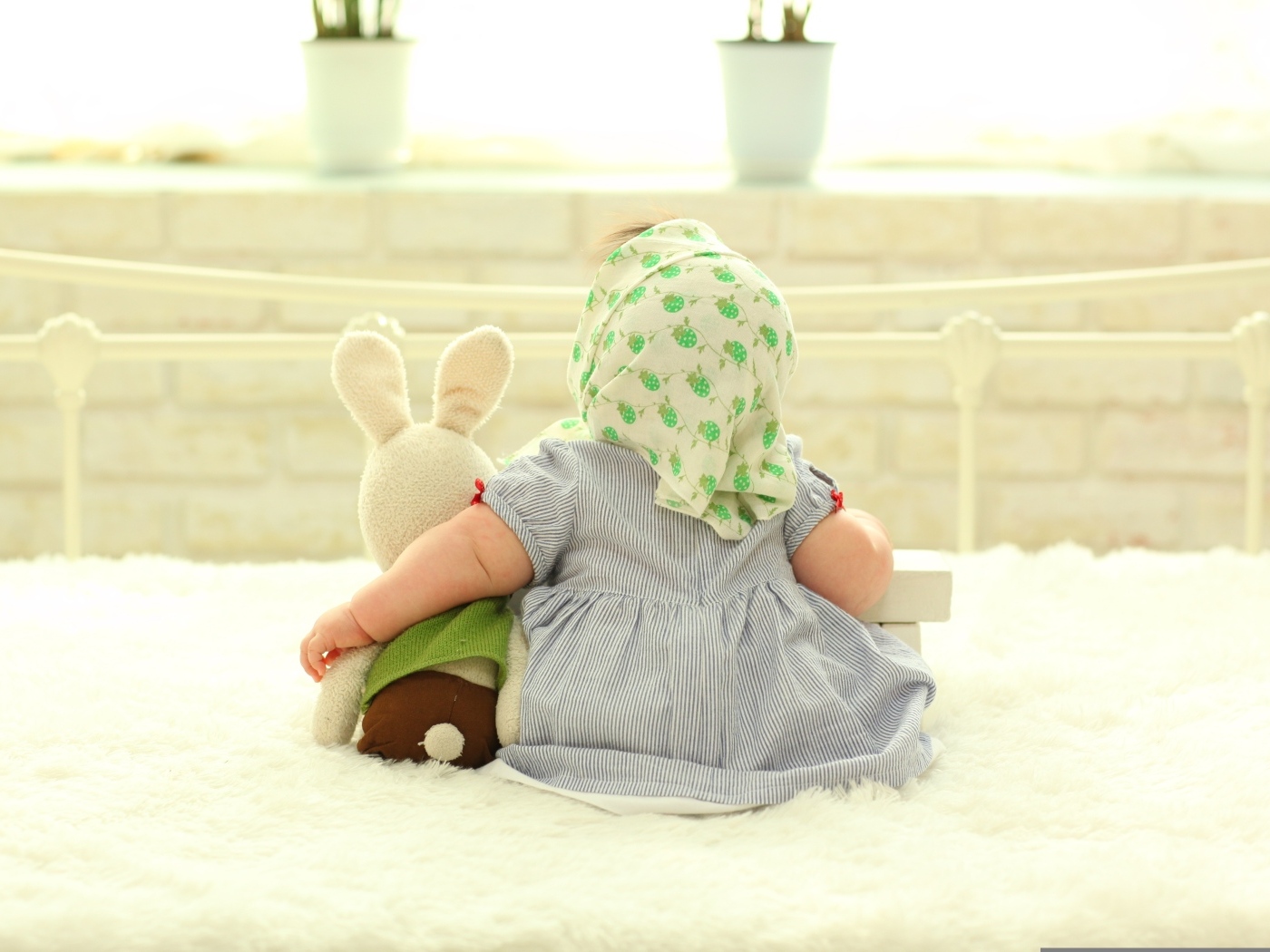 Маленькая девочка обнимает игрушечного зайца