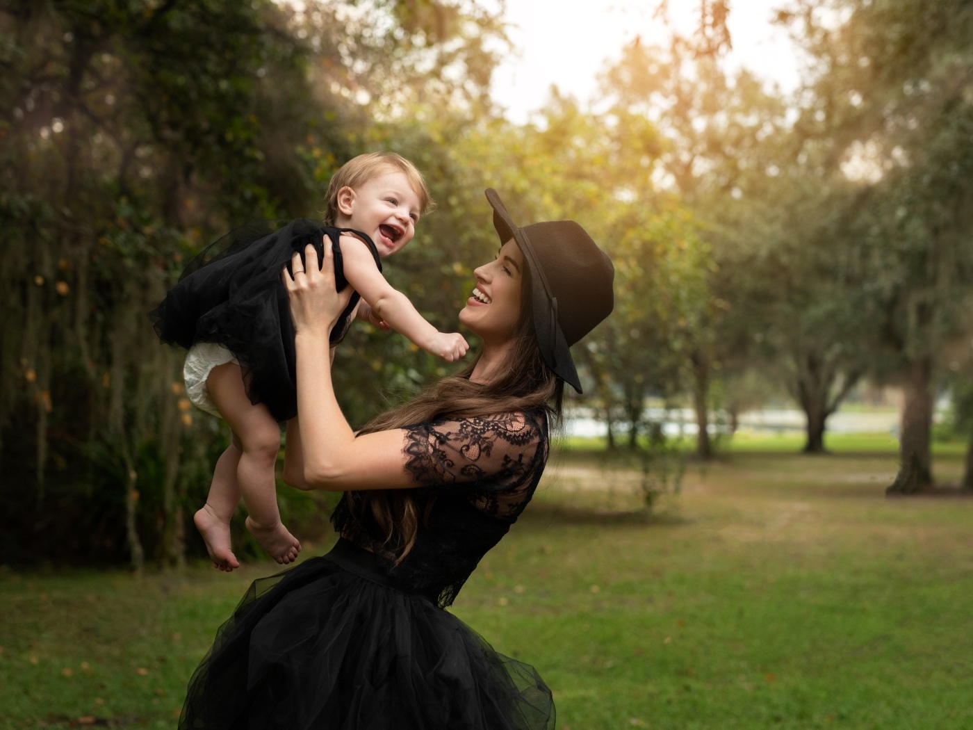 Мама держит улыбающуюся дочь на руках