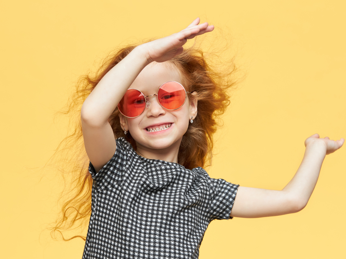 Улыбающаяся рыжеволосая девочка в очках