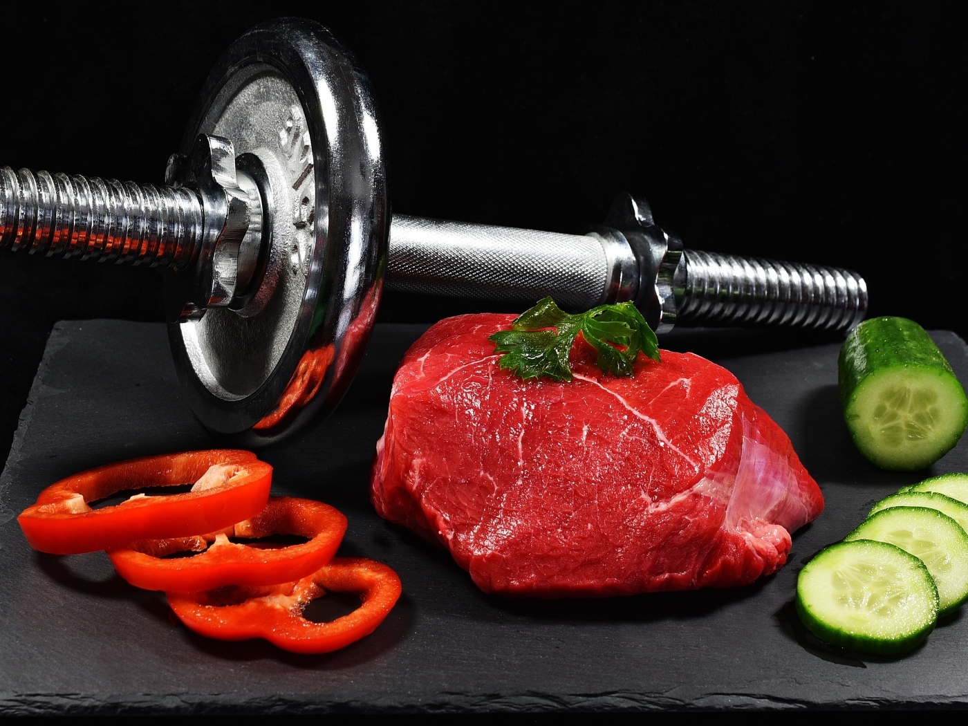 Dumbbell and healthy food for an athlete on a black background