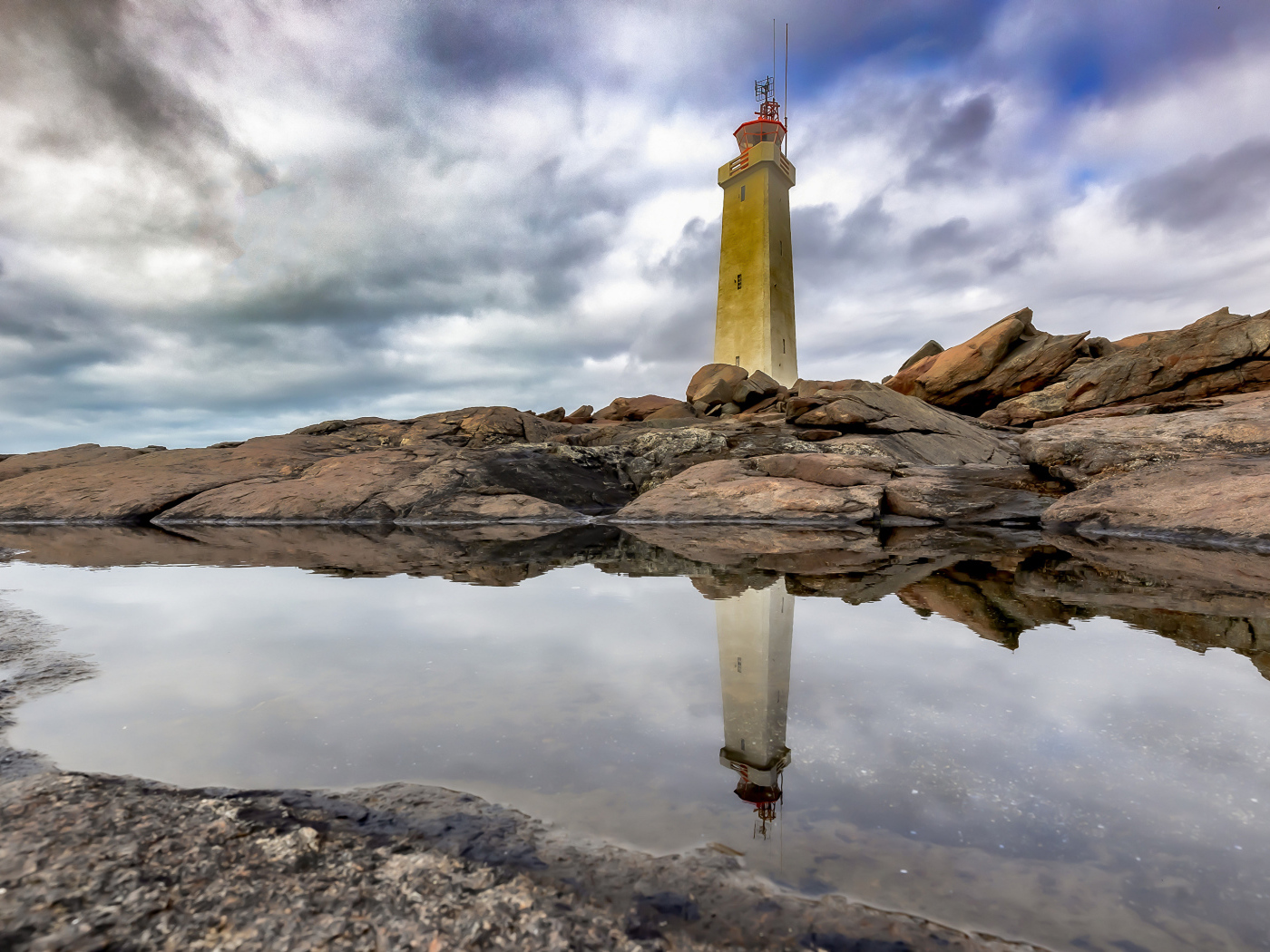 Маяк на больших камнях на берегу, Исландия