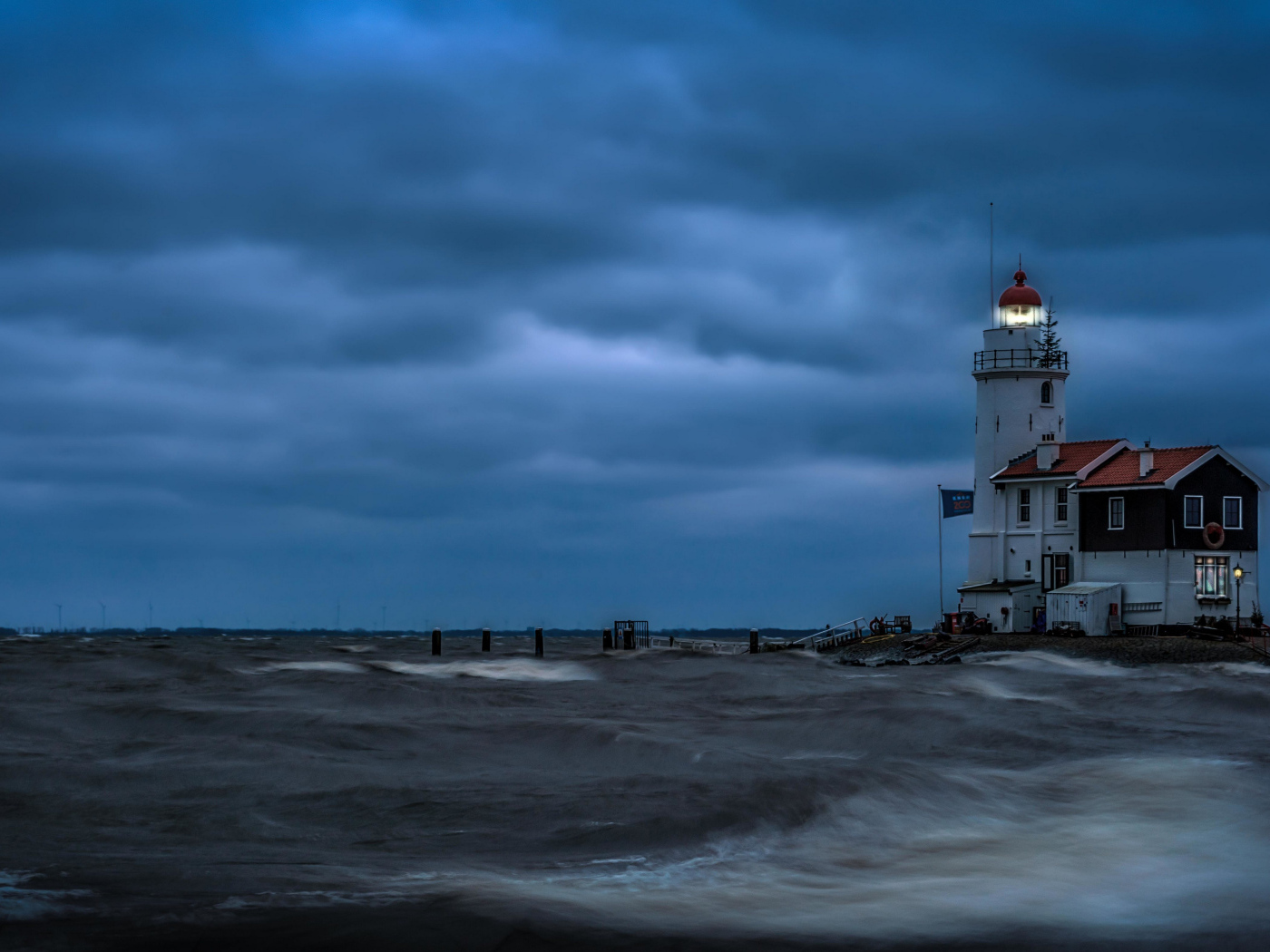 Маяк на морском побережье в сумерках, Голландия. Нидерланды