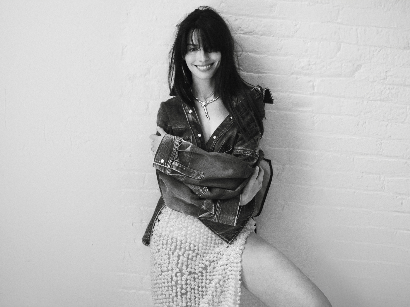 Актриса Энн Хэтэуэй стоит у стены черно-белое фото