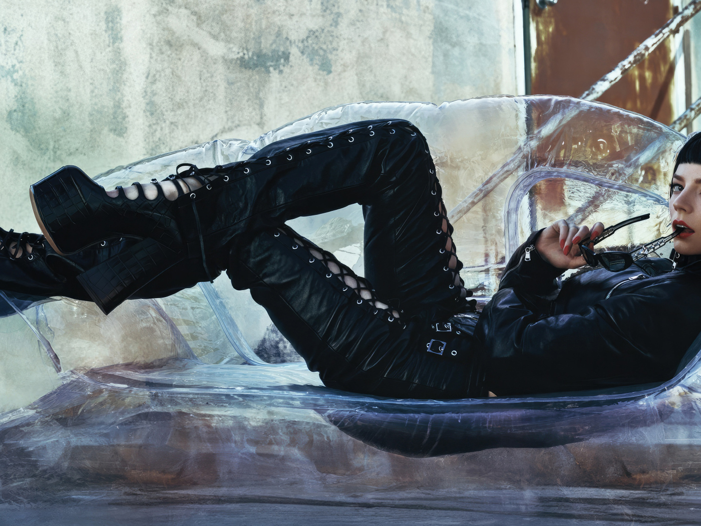 Актриса Аня Тейлор-Джой в черном костюме лежит на диване