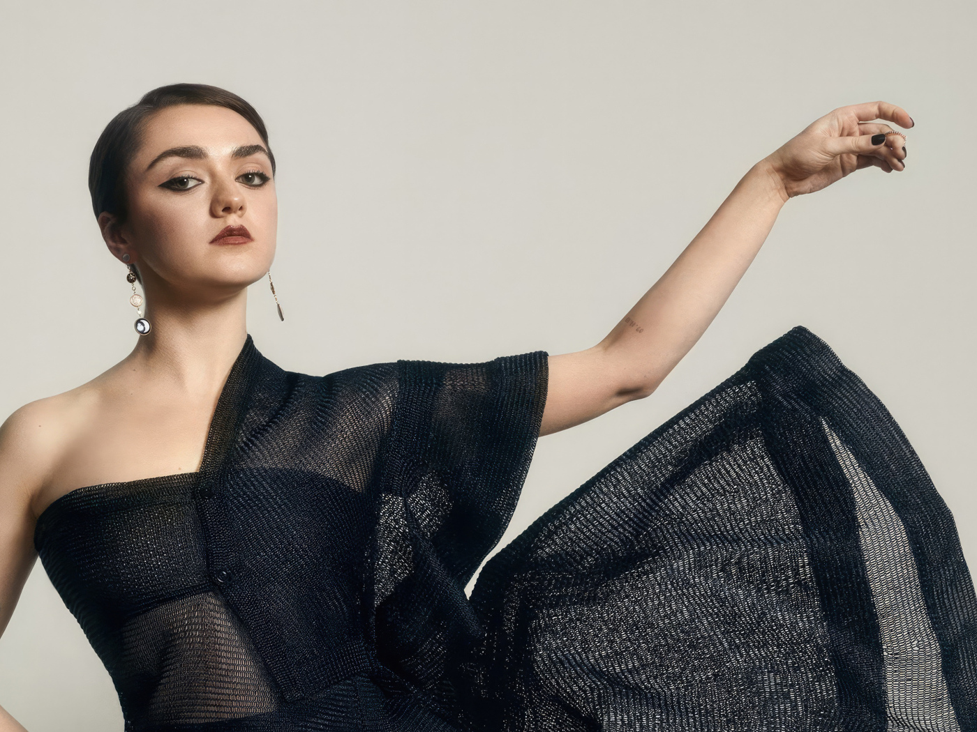 Актриса Мэйси Уильямс в черном платье на сером фоне