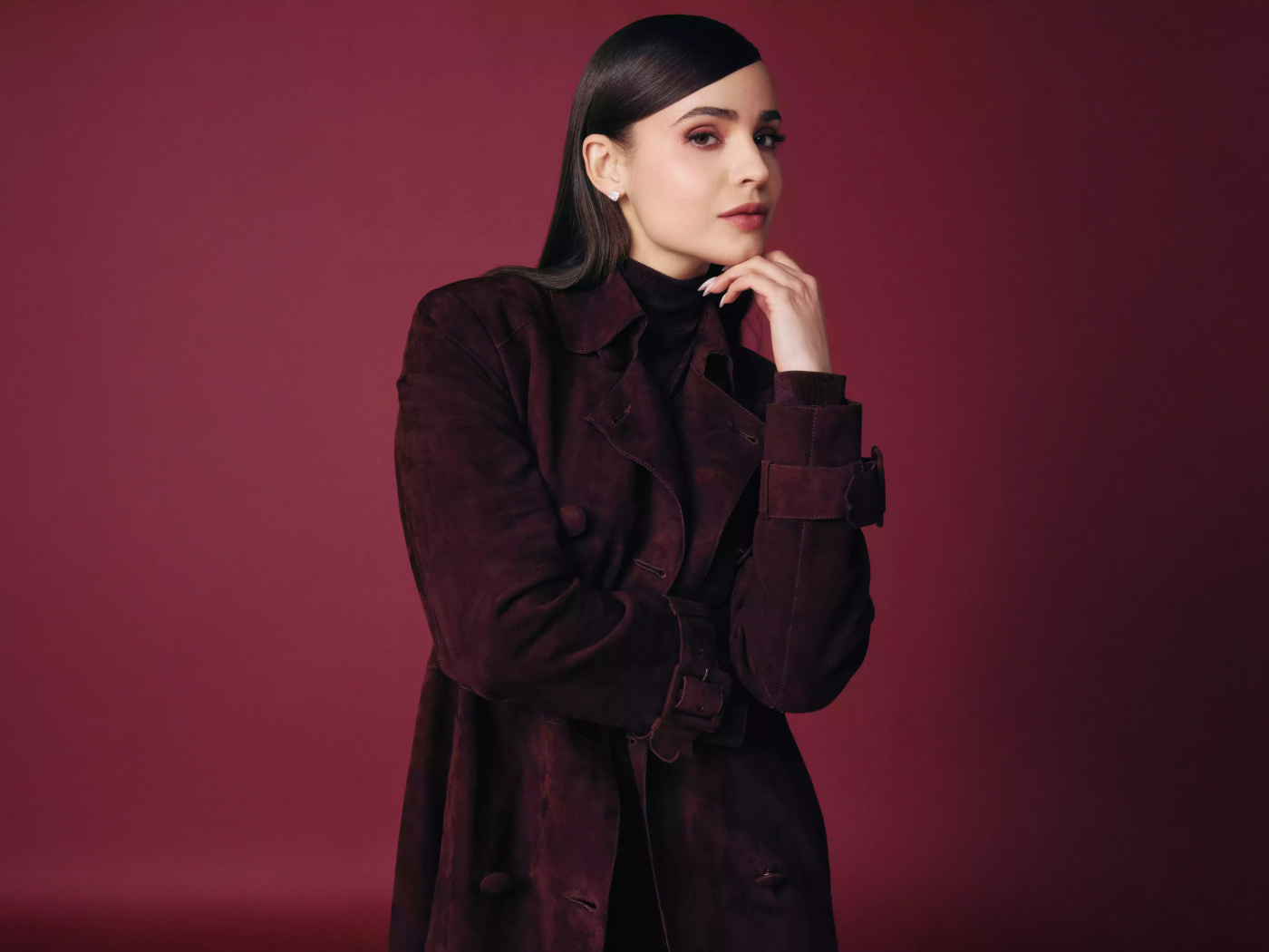 Актриса София Карсон в пальто на бордовом фоне