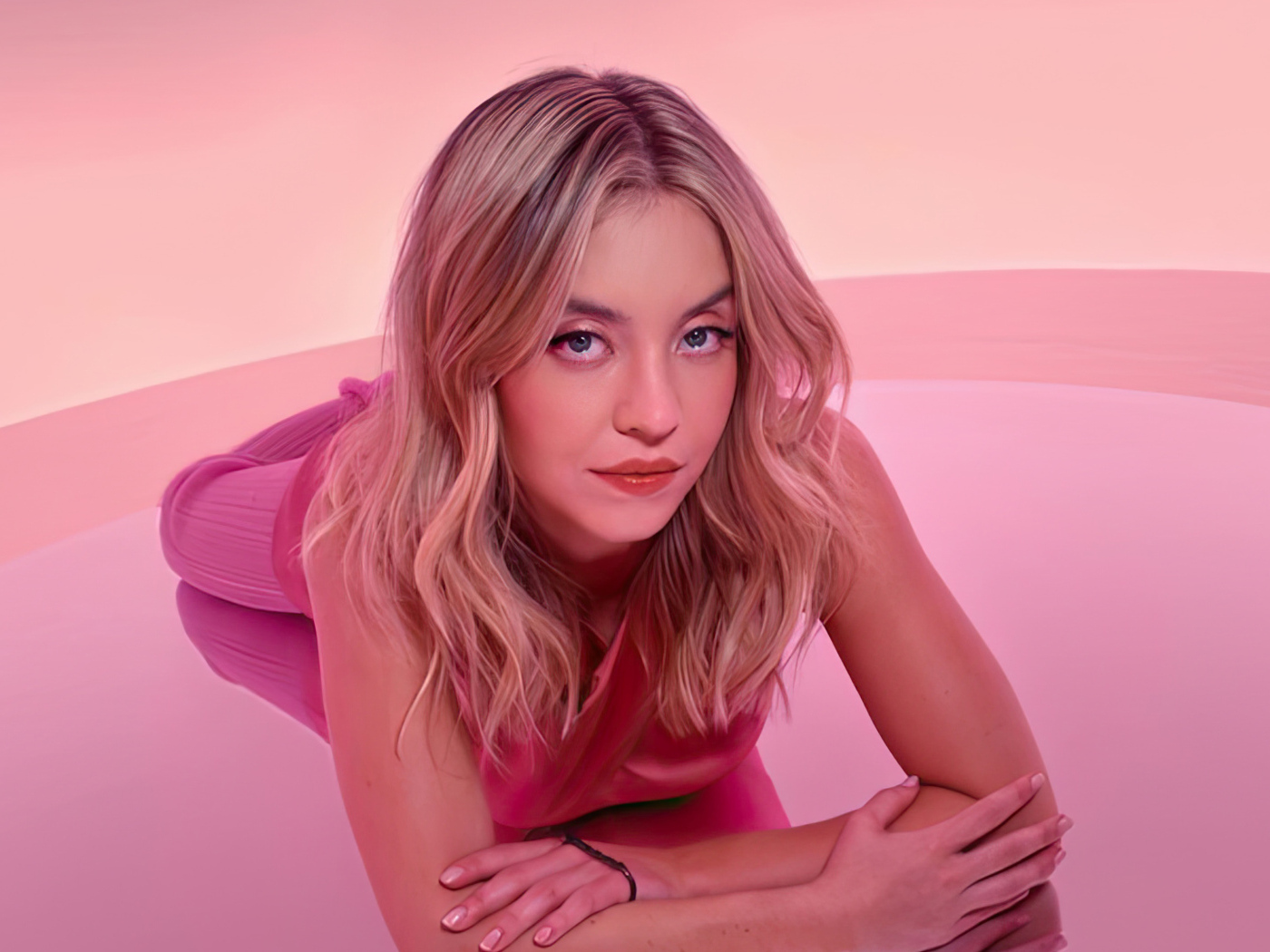 Милая блондинка Сидни Суини лежит на розовом фоне