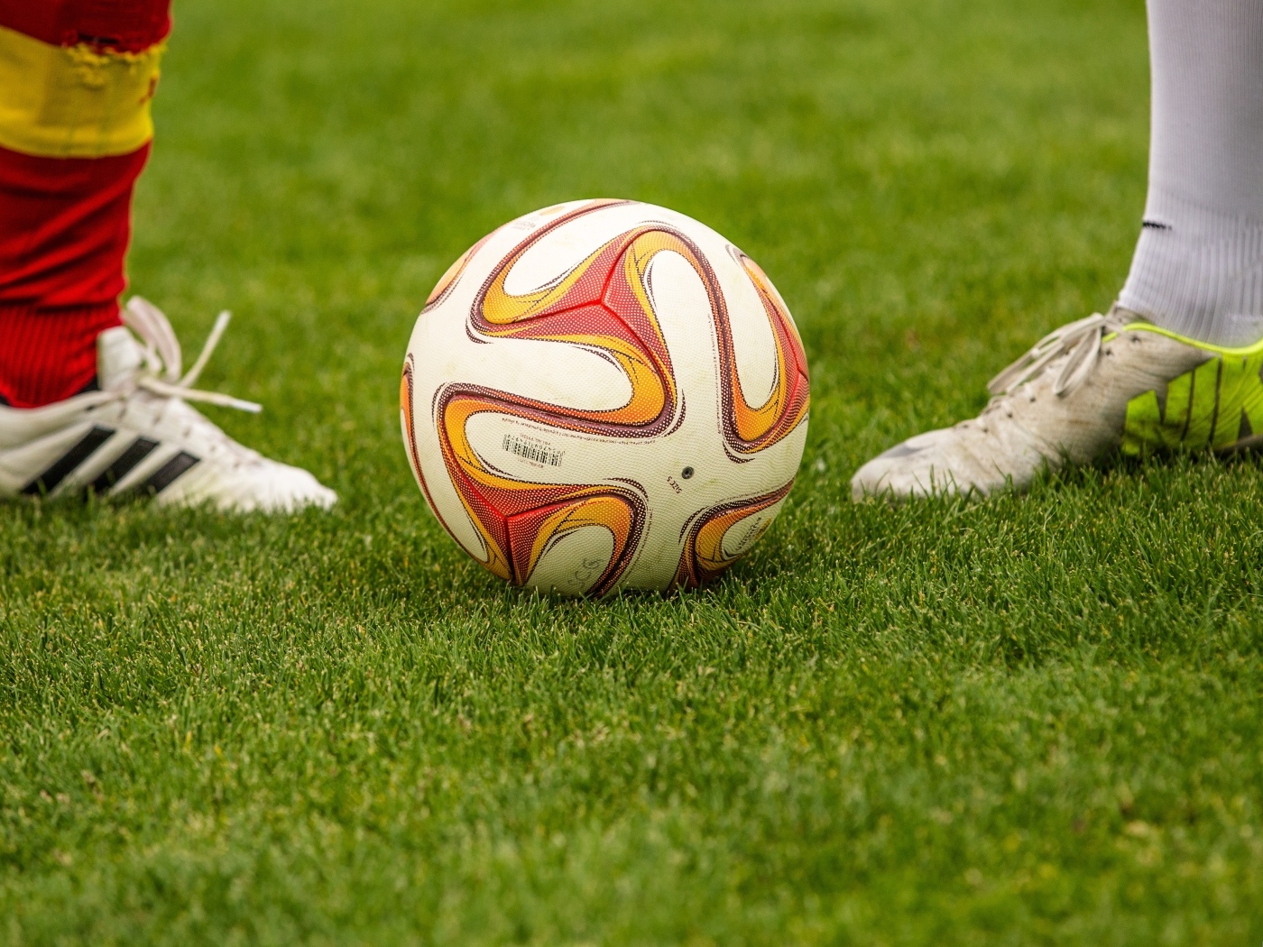 Футболисты с мячом на зеленой траве