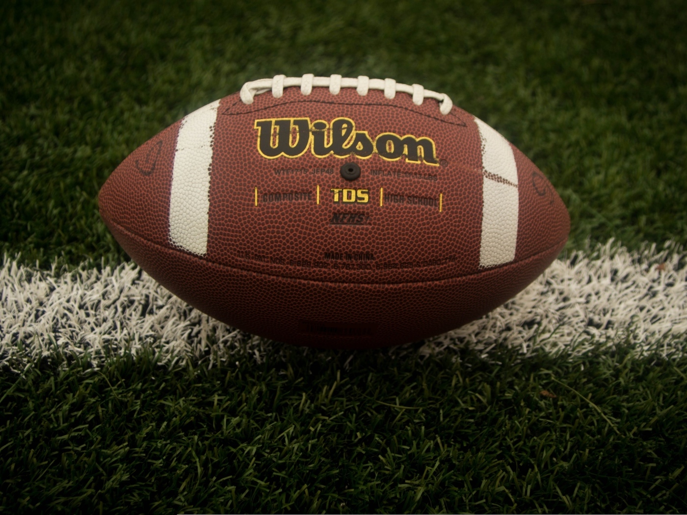 Кожаный мяч для американского футбола на зеленой траве