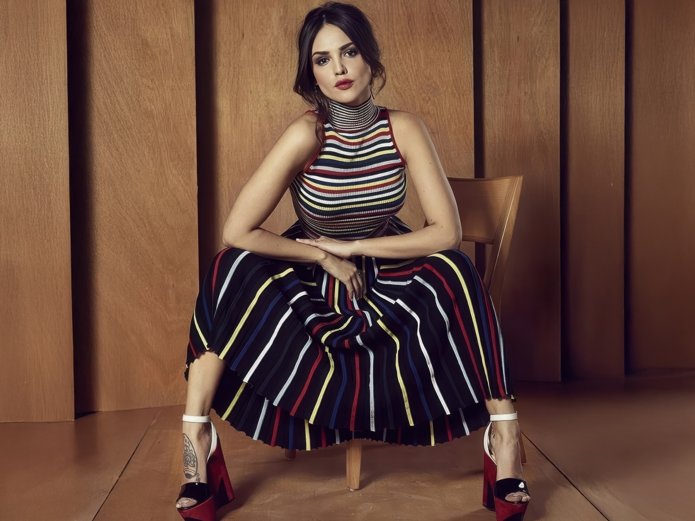 Мексиканская актриса Эйса Гонсалес в юбке сидит на стуле