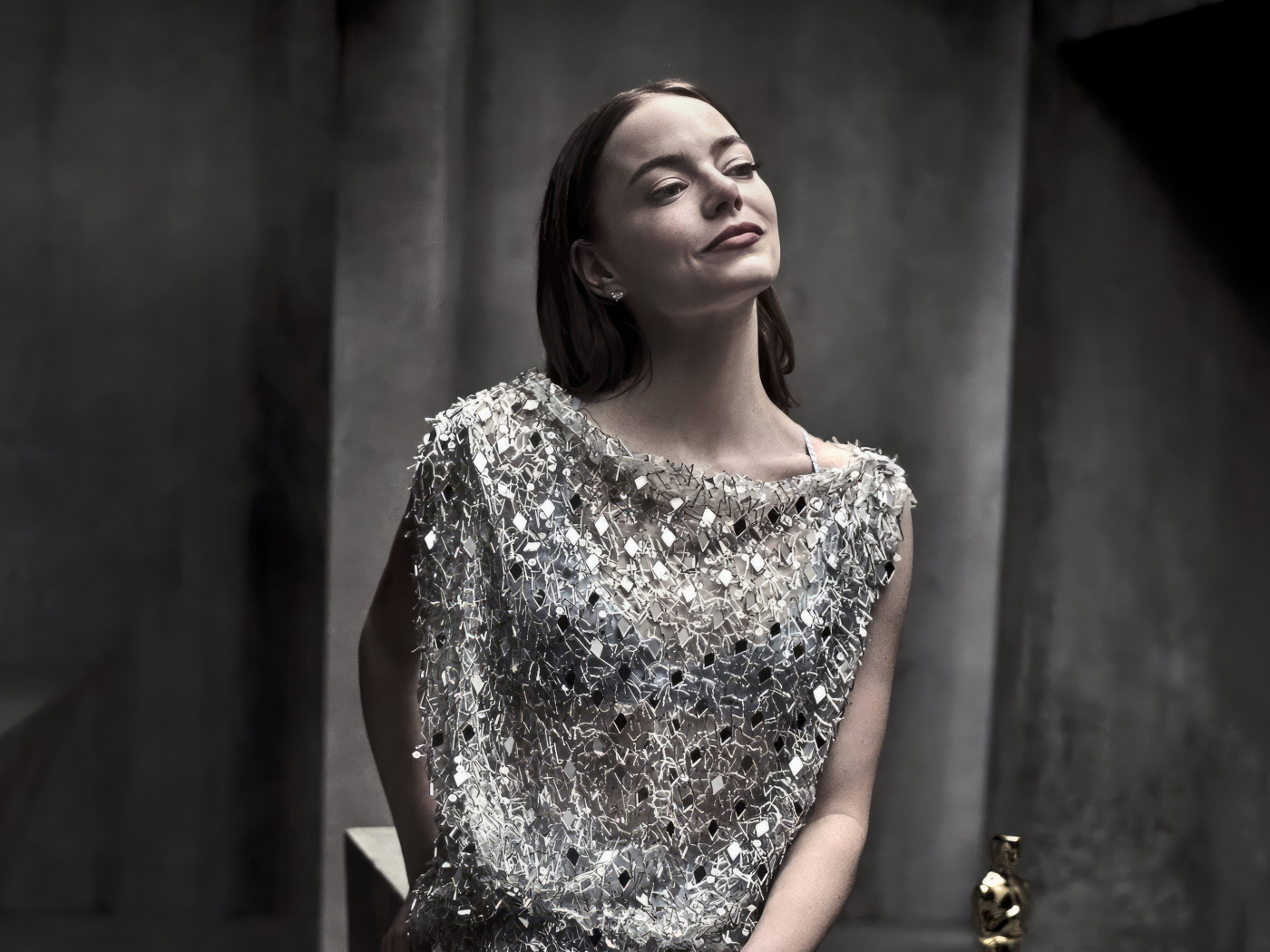 Рыжеволосая актриса Эмма Стоун в блестящем платье в серой комнате