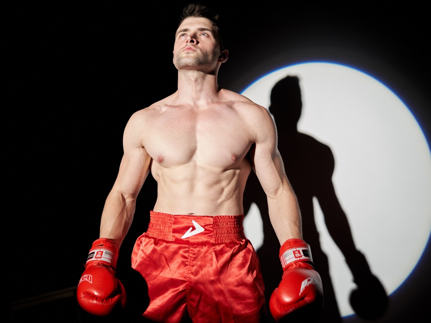 Сильный мужчина боксер в свете софитов