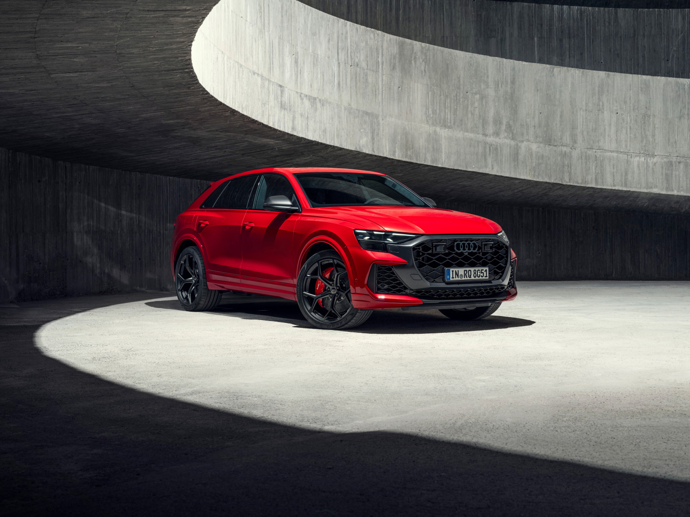 Красный автомобиль Audi RS Q8 performance 2024 года в здании