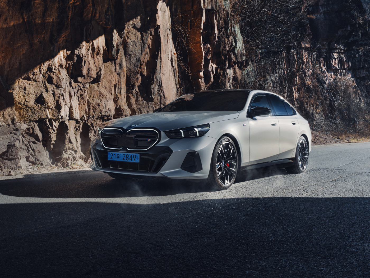 Серебристый автомобиль BMW i5 M60 у горы