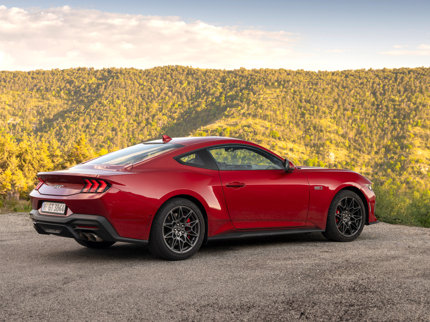 Красный автомобиль Ford Mustang GT 2024 года вид сзади