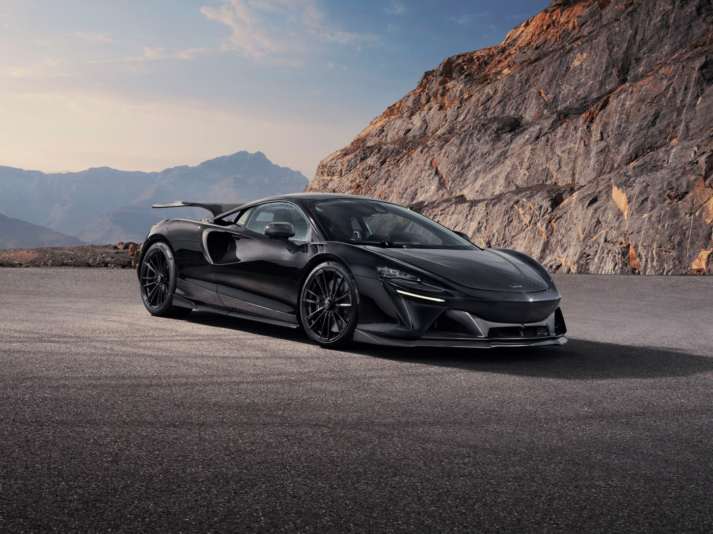 Вид спереди на автомобиль Novitec McLaren Artura 2024 года у горы