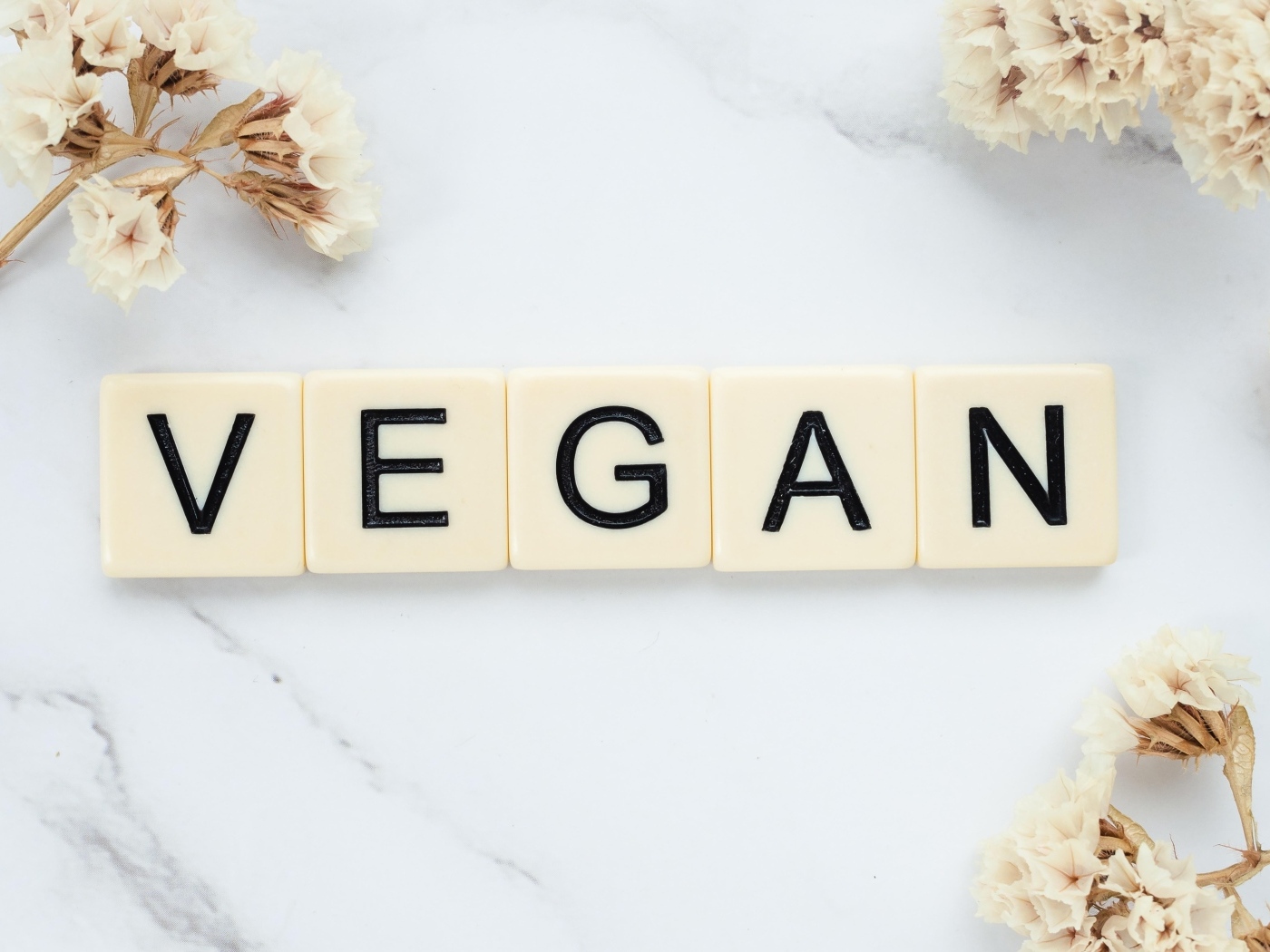Надпись веган на столе с цветами