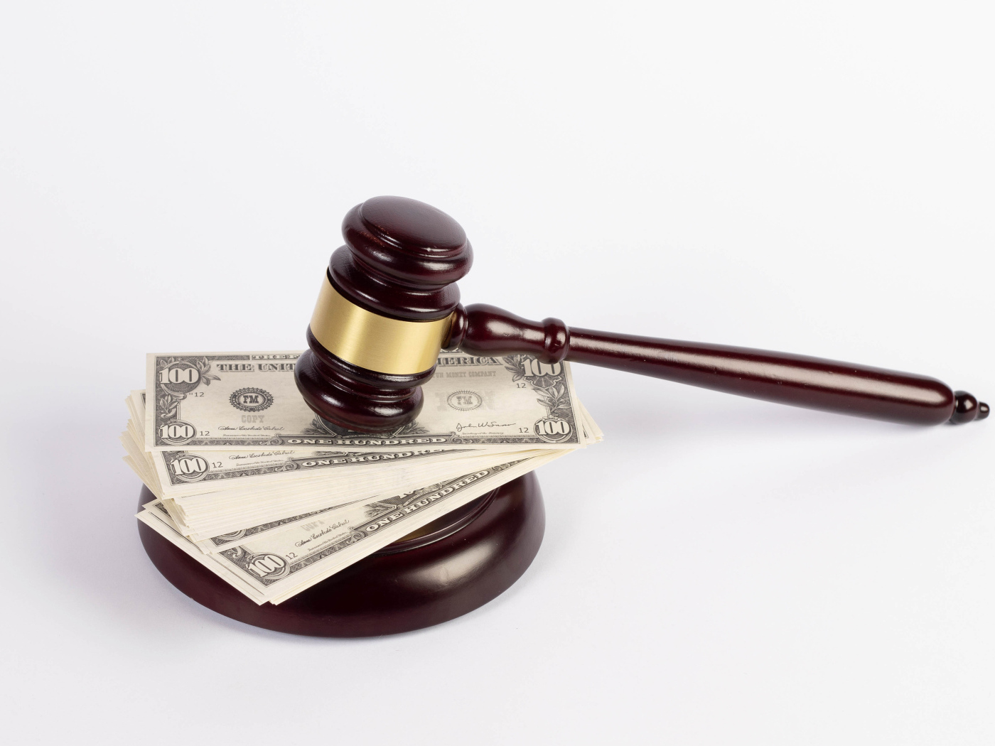 Молоток судьи и пачка долларов на белом фоне