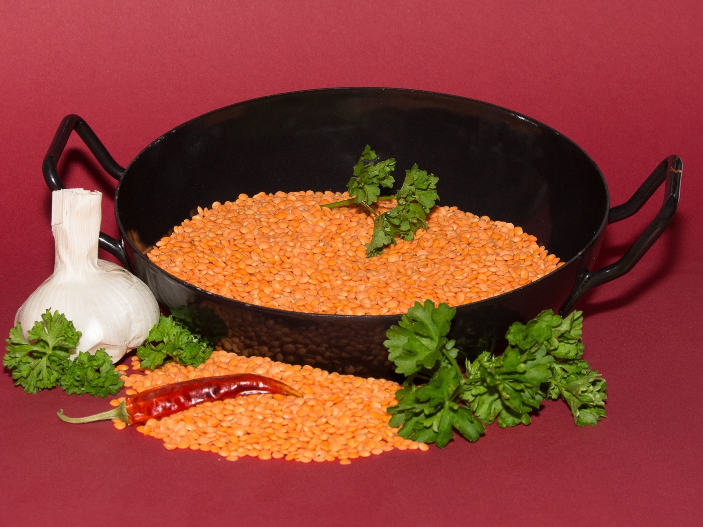 Бобы с чесноком и петрушкой на красном фоне