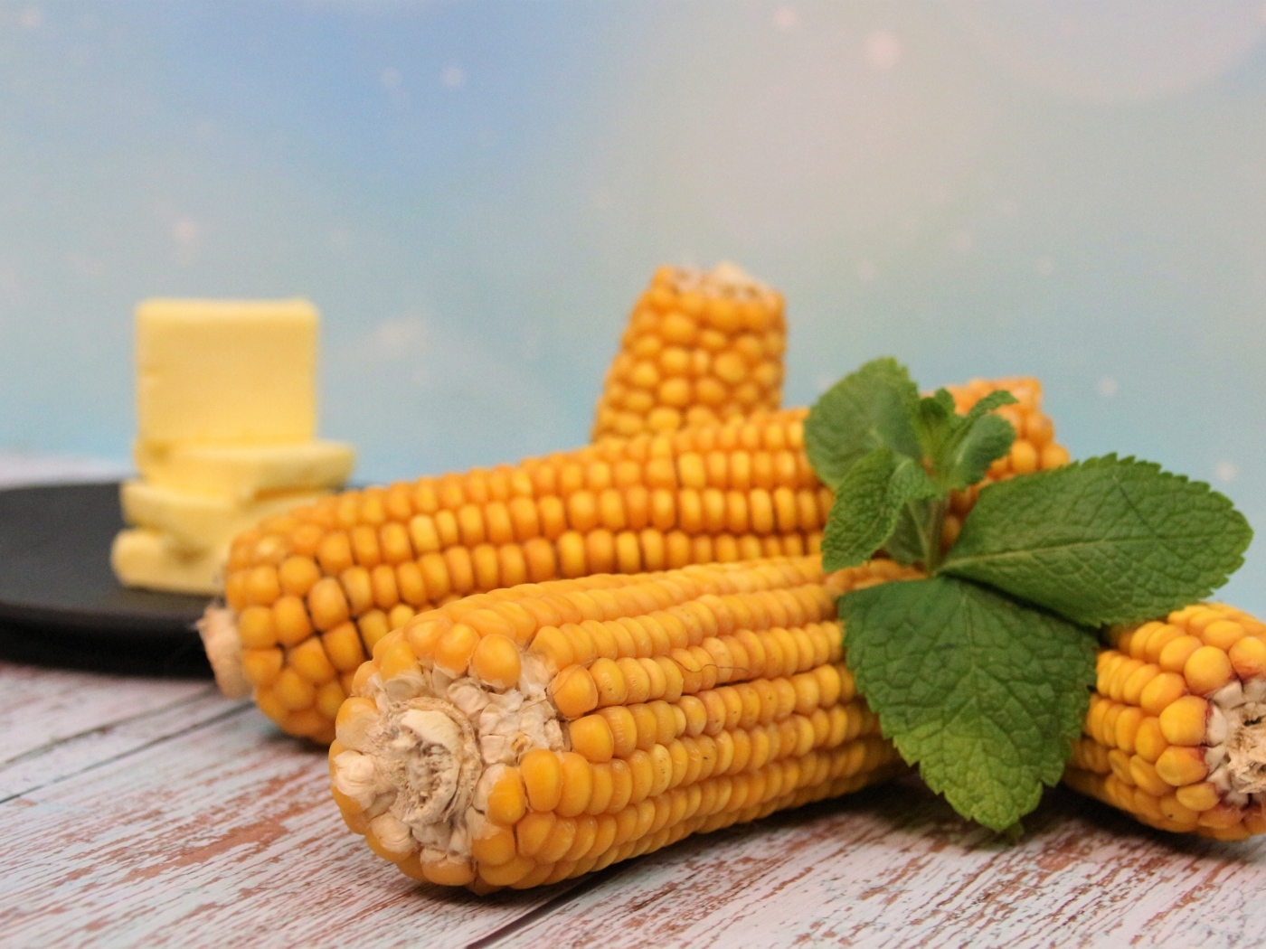 Желтая кукуруза с маслом и веточкой мяты