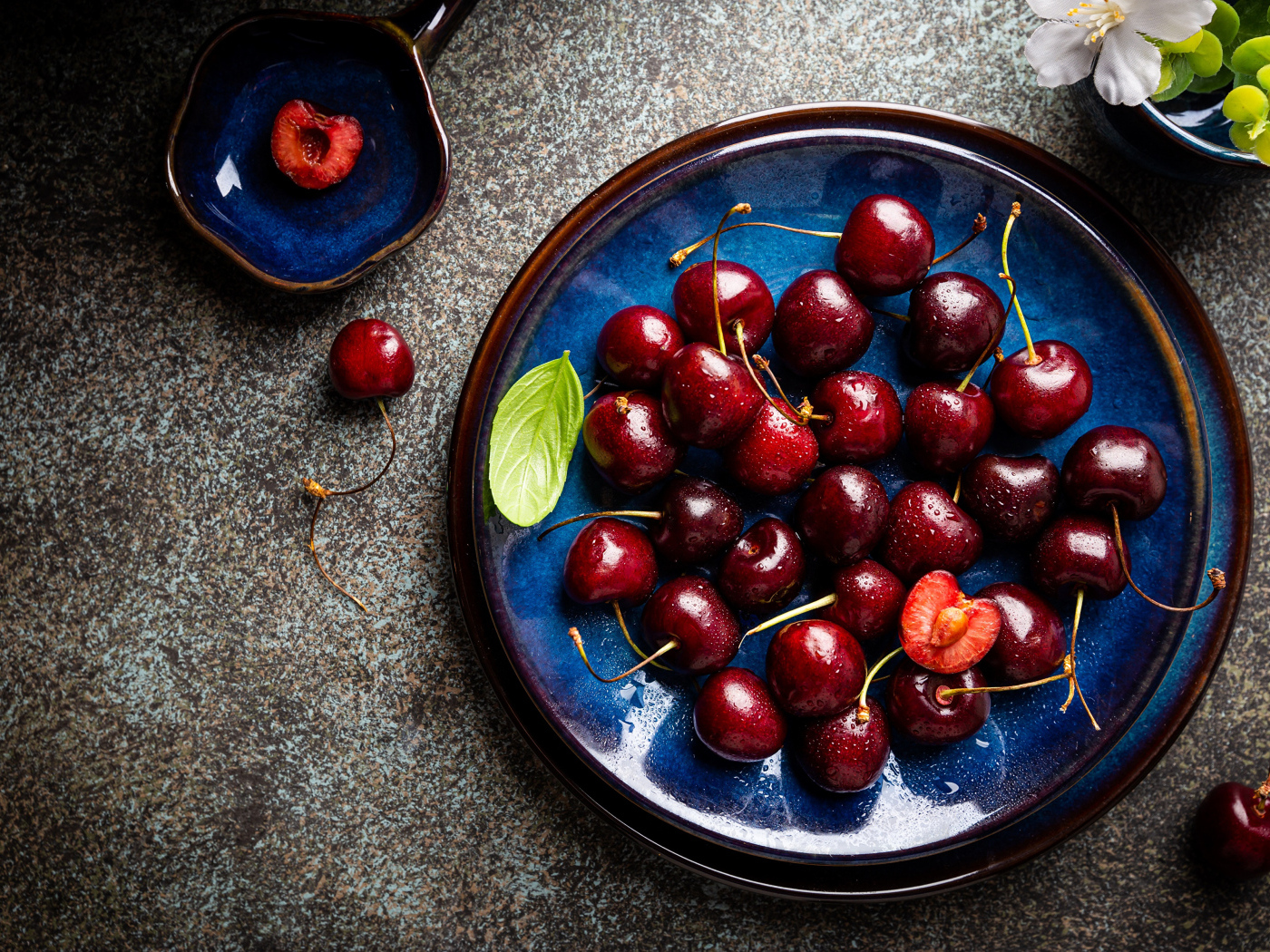 Синяя тарелка с красными ягодами черешни 