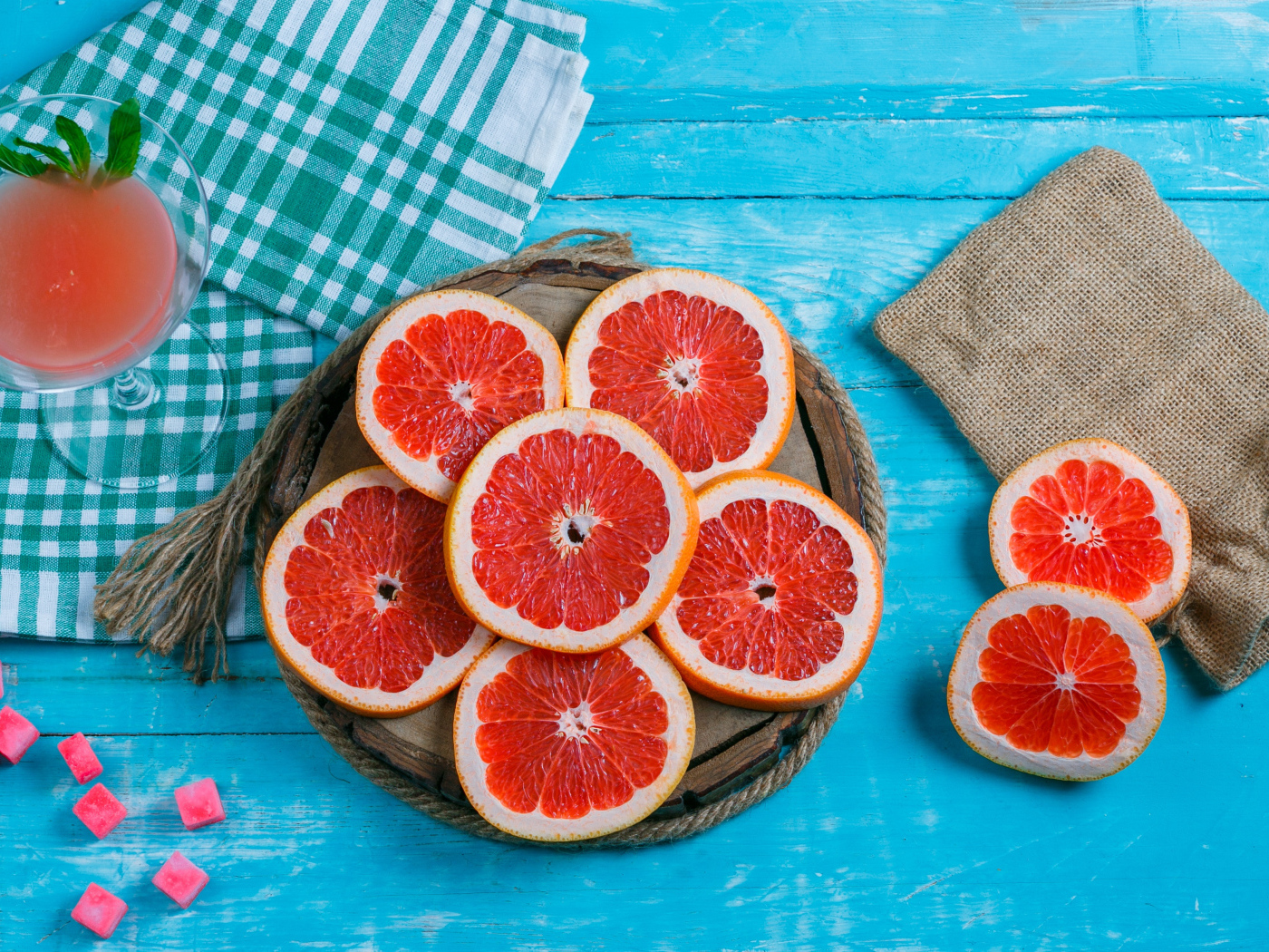 Нарезанный грейпфрут с соком на голубом столе