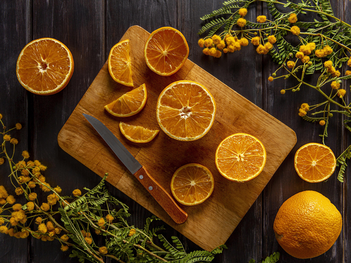 Нарезанный апельсин на доске на столе с цветами