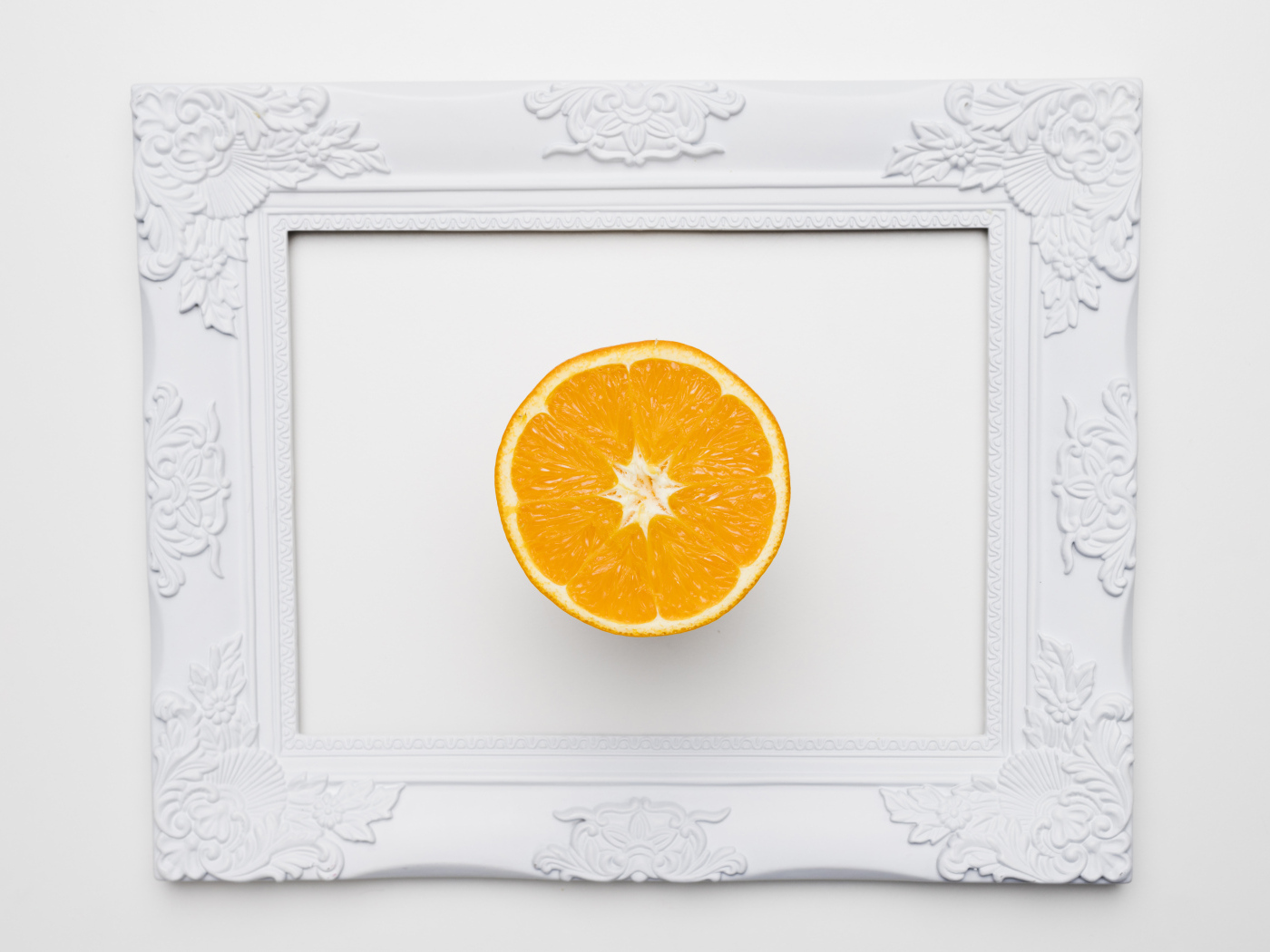 Белая рамка для фото с половиной апельсина