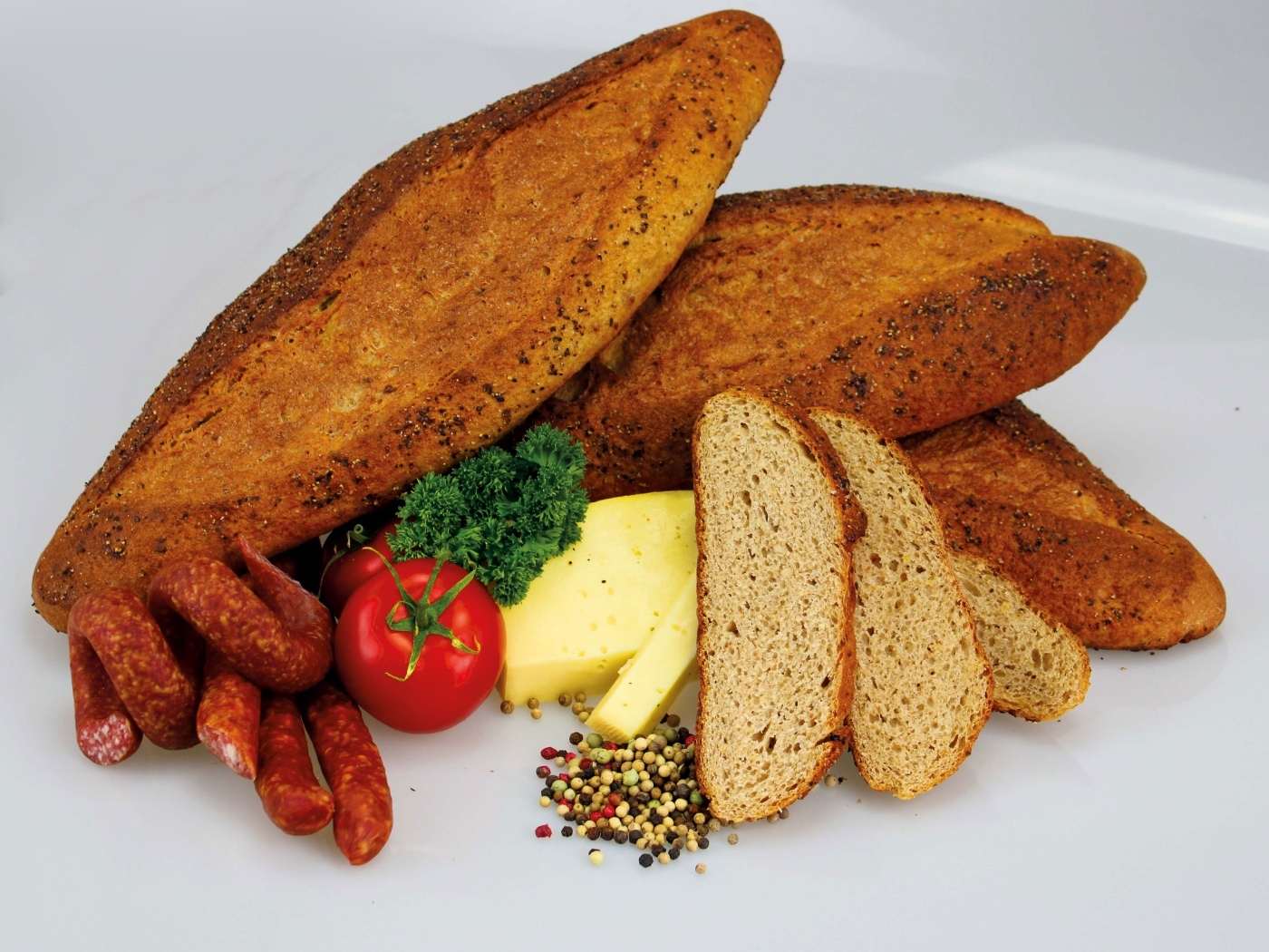 Свежая выпечка на столе с колбасой, сыром и помидорами