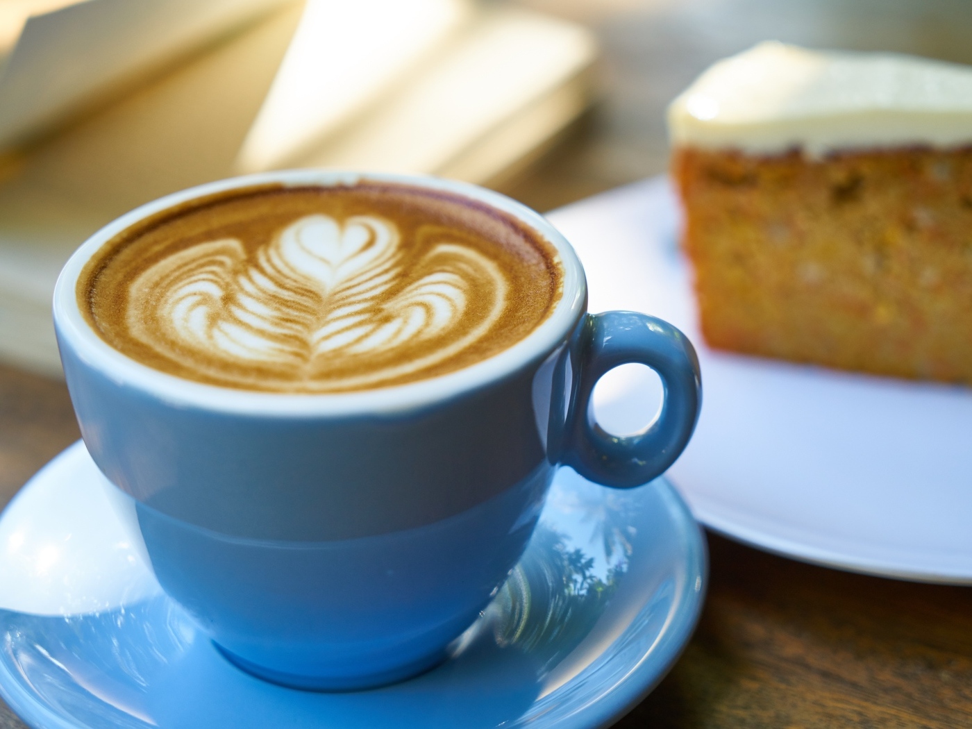 Чашка ароматного горячего кофе с рисунком на пене на столе на завтрак